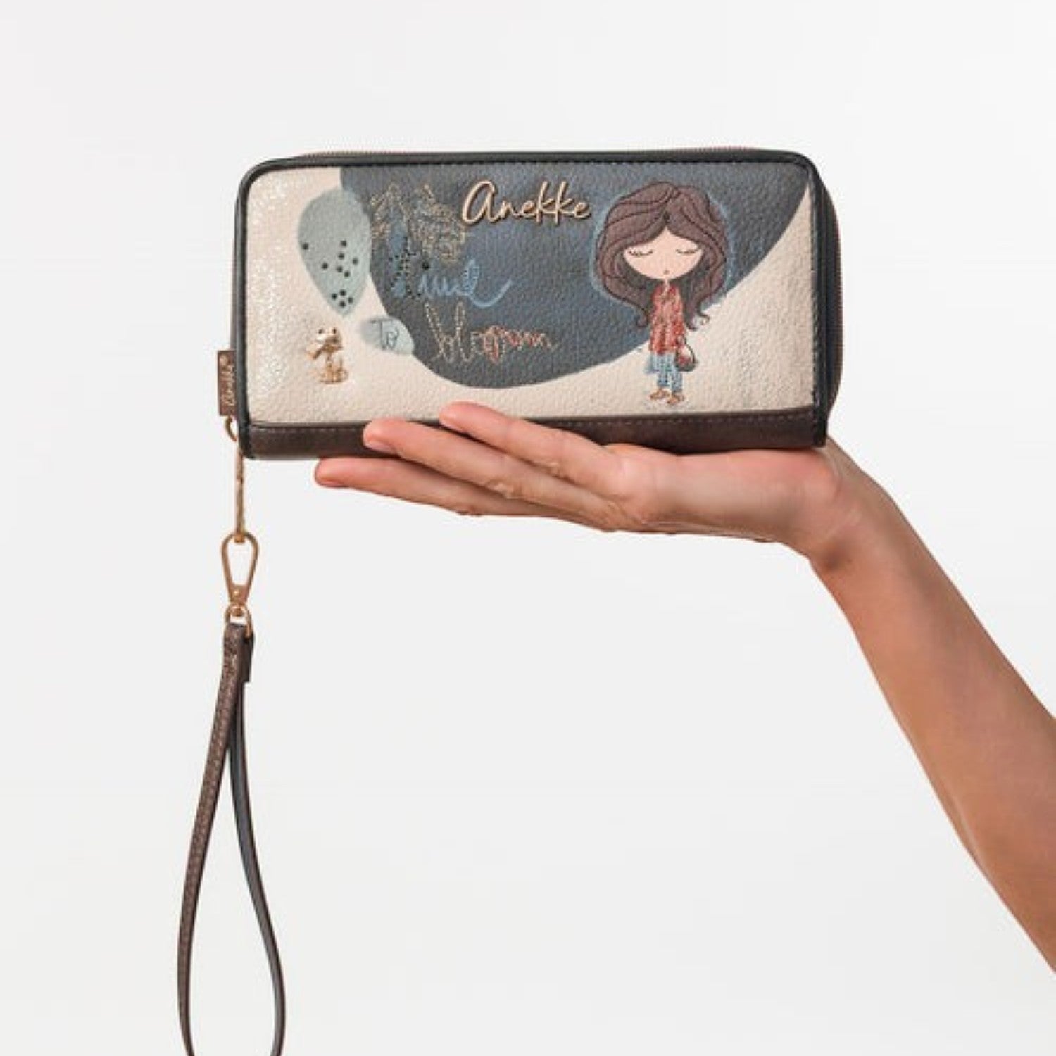Lieblingstasche Anekke wallet with illustrated girl, floral details, and wrist strap held in a hand