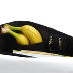 Lieblingstasche Barkasse Mini black canvas bag with internal pockets holding bananas, pens, and a notebook.