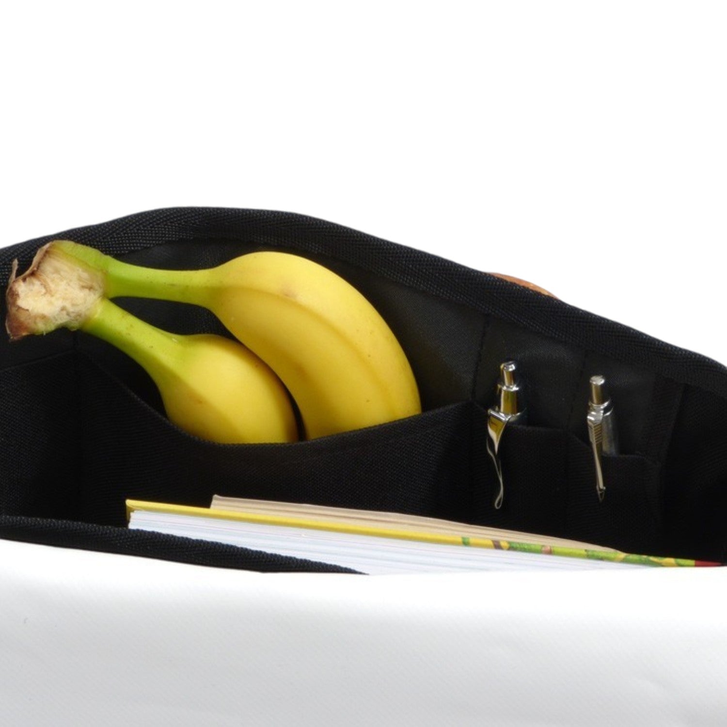 Lieblingstasche Barkasse Mini black canvas bag with internal pockets holding bananas, pens, and a notebook.