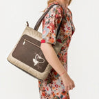 Lieblingstasche shoulder bag in beige and brown with quilted texture and butterfly embroidery worn by a woman