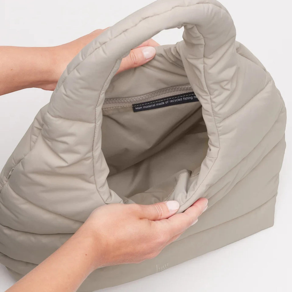 Lieblingstasche beige wavy puffer shoulder bag with recycled material interior label held by hands