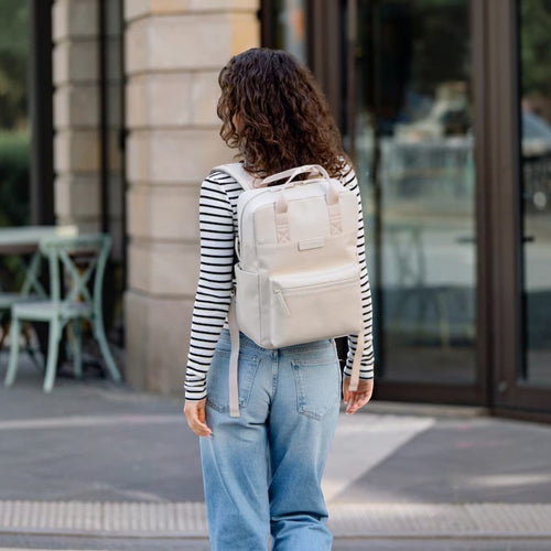 Lieblingstasche Bergen Pro backpack in beige worn by a woman with long curly hair in a city setting.