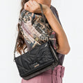 Lieblingstasche black cross-body bag with decorative stitching and chain strap worn over the shoulder