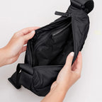Lieblingstasche black wavy puffer moon bag with open zipper showing interior lining and recycled material label