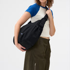 Lieblingstasche black slouchy crossbody bag worn by a woman with a casual outfit