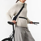 Lieblingstasche black water-resistant sling bag worn crossbody by a cyclist in a beige sweater