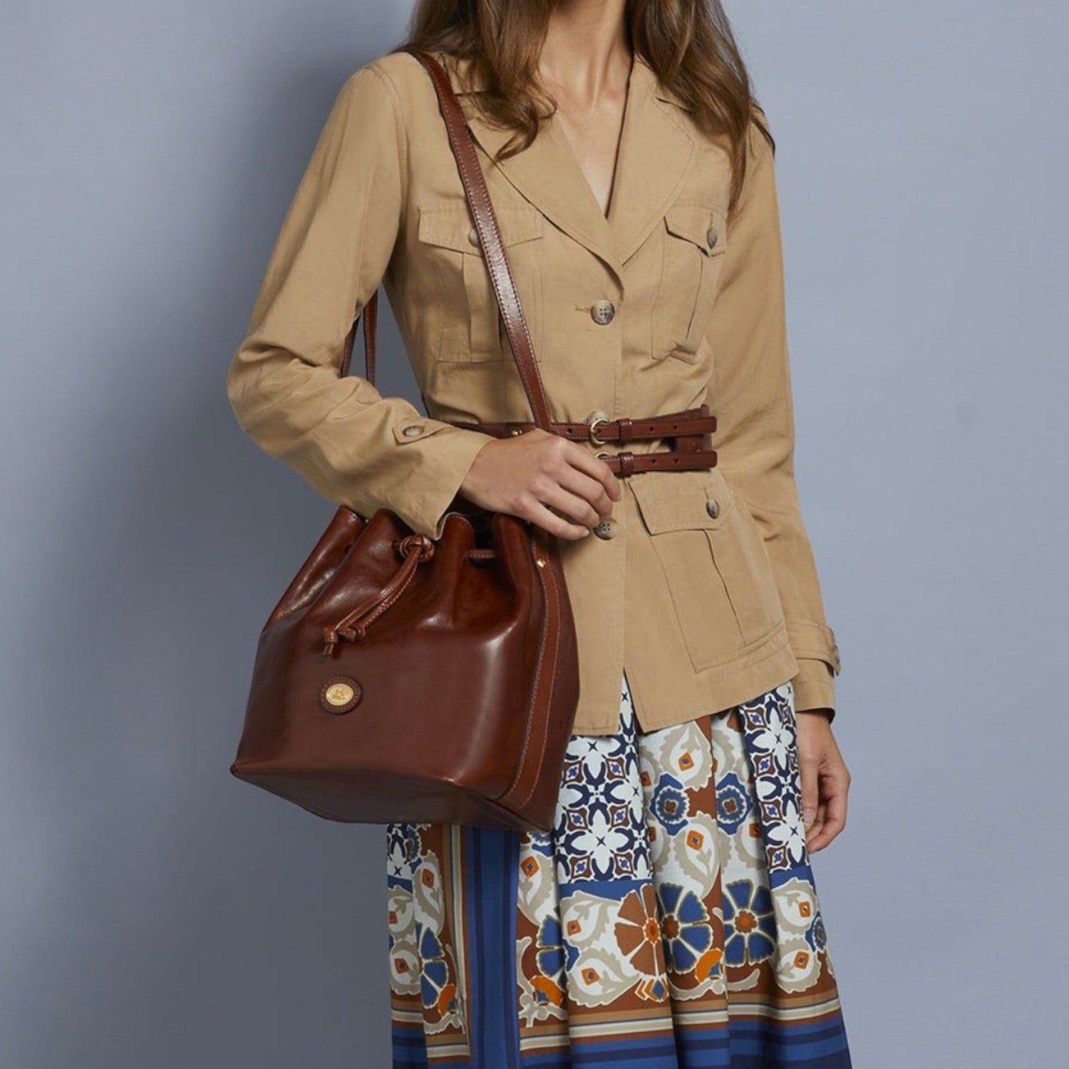 Lieblingstasche brown leather drawstring bucket bag with adjustable shoulder strap worn by a model.