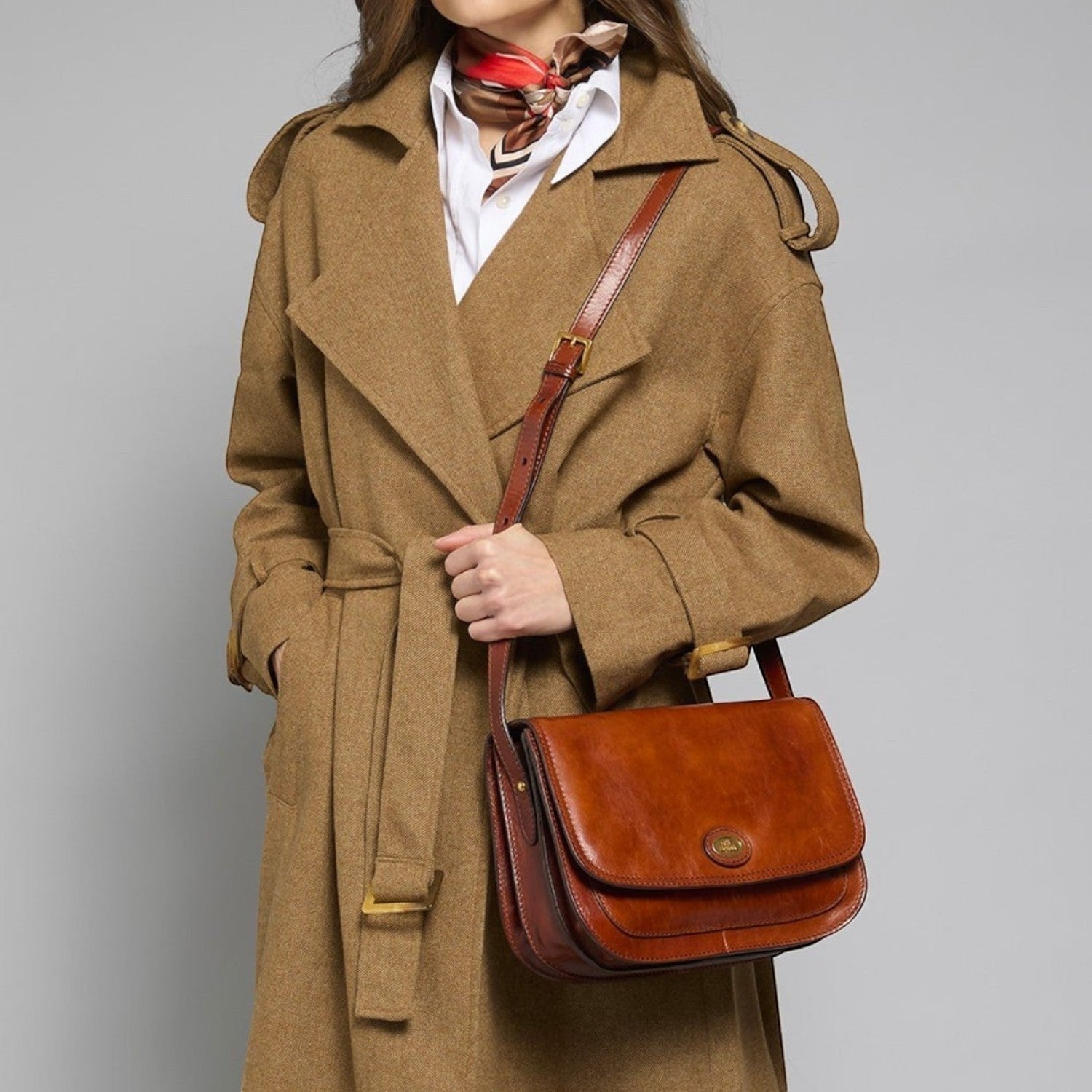 Lieblingstasche brown leather crossbody bag with multiple compartments worn by a woman in a tan coat.