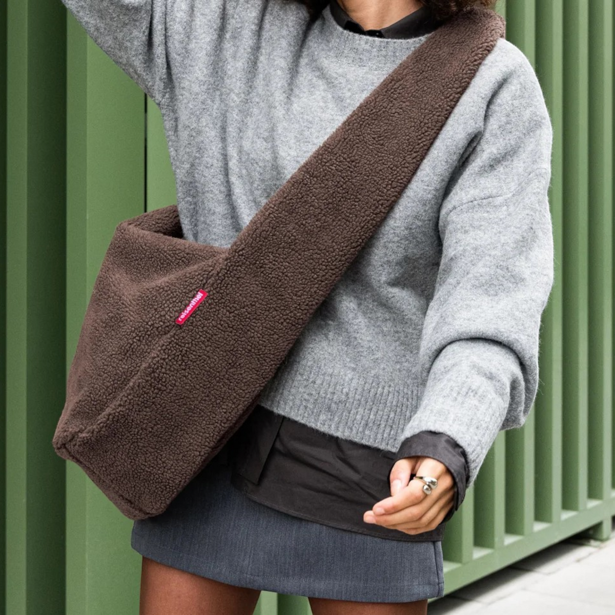 Lieblingstasche brown teddy fleece moonbag worn as a crossbody bag over a grey sweater
