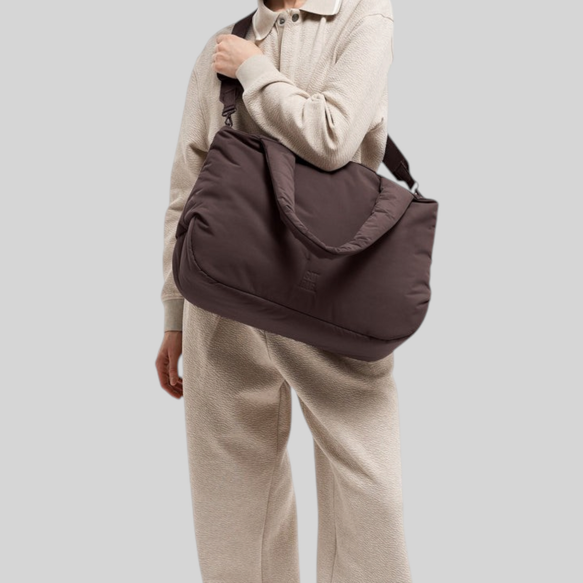 Lieblingstasche Cloud Horizon tote bag in dark brown, worn over the shoulder by a woman in a beige lounge set.
