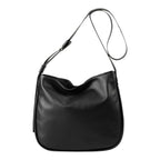 Lieblingstasche Coral black leather hobo bag with an adjustable shoulder strap against a white background