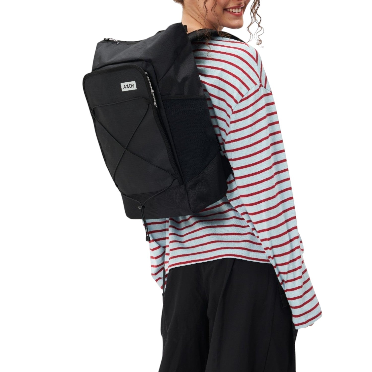 Lieblingstasche Day Pack FLX in black worn by a smiling woman in a striped long-sleeve shirt