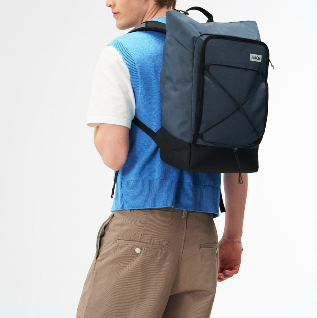 Lieblingstasche Day Pack FLX in blue and black worn by a model against a white background