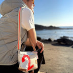 Lieblingstasche Deern Lütt crossbody bag in white canvas with a red number 2 and orange striped shoulder strap