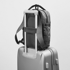 Lieblingstasche eoto Small16 compact daypack in grey, attached to a suitcase handle for travel convenience.