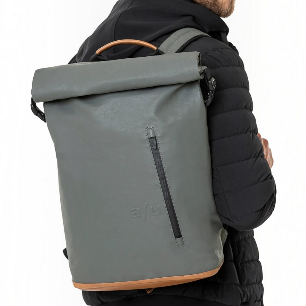 Lieblingstasche a/u by aunts & uncles Fukui rolltop backpack in grey coated canvas with tan leather details on a man