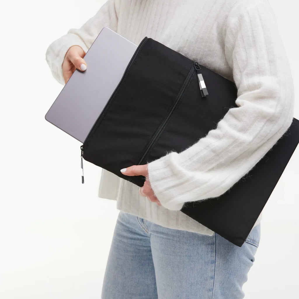 Lieblingstasche GOT BAG Rolltop Lite 2.0 black laptop sleeve being held by a person with a laptop inside