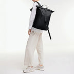 Lieblingstasche GOT BAG Rolltop Lite 2.0 black backpack worn by a woman in a white shirt and beige trousers