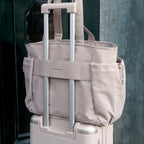 Lieblingstasche Hellvi Pro Large beige travel tote bag with luggage sleeve attached to a matching suitcase handle.