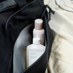 Lieblingstasche Hellvi Pro Large black bag with a zippered side pocket containing a bottle of body wash and spray