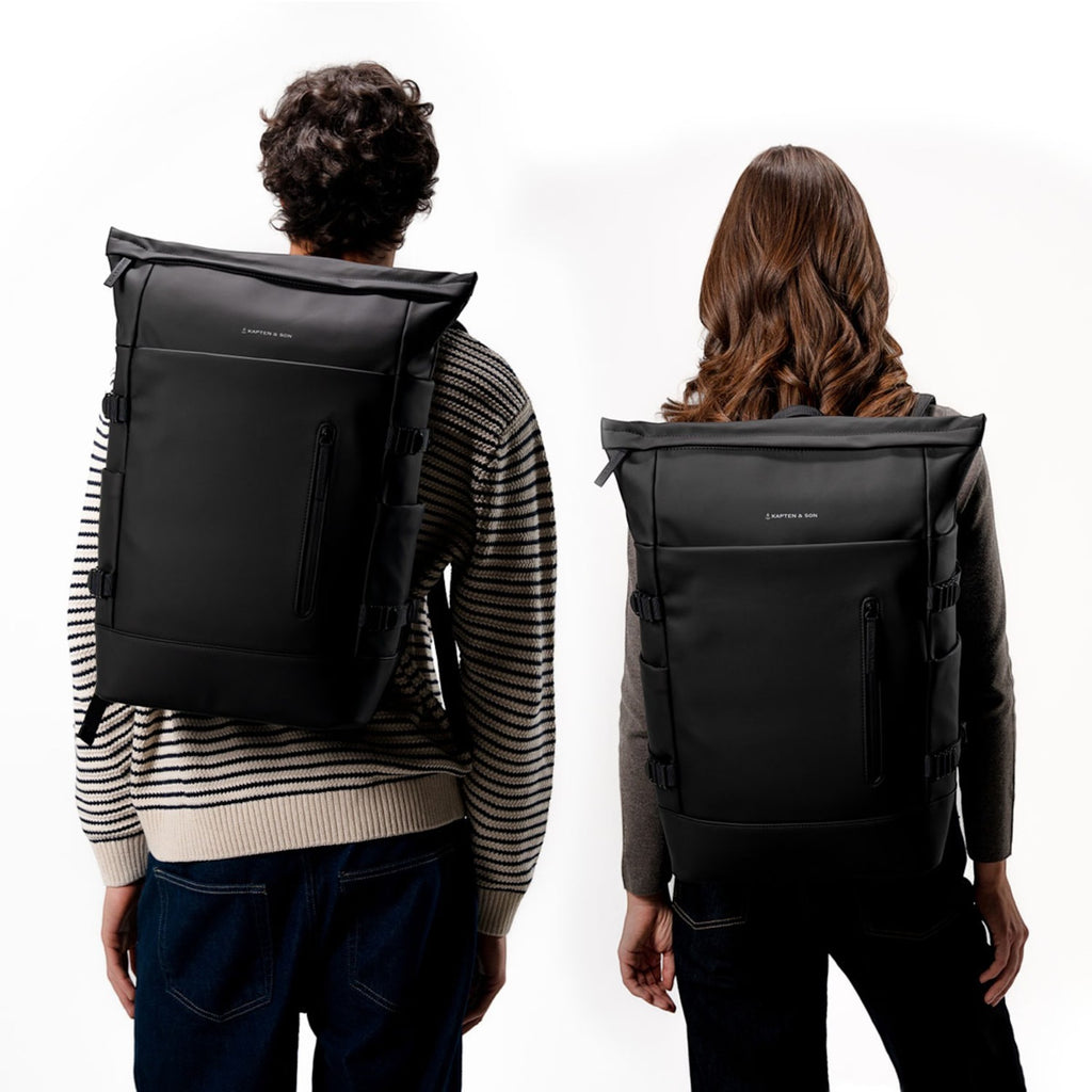 Lieblingstasche Helsinki Pro black rolltop backpack worn by a man and woman against a white background