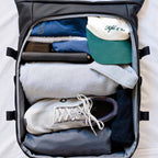 Lieblingstasche Helsinki Pro suitcase packed with organized travel essentials including sneakers, clothing, and a cap.