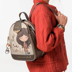 Lieblingstasche backpack featuring a whimsical girl illustration, beige and brown tones, worn on a woman's shoulder.