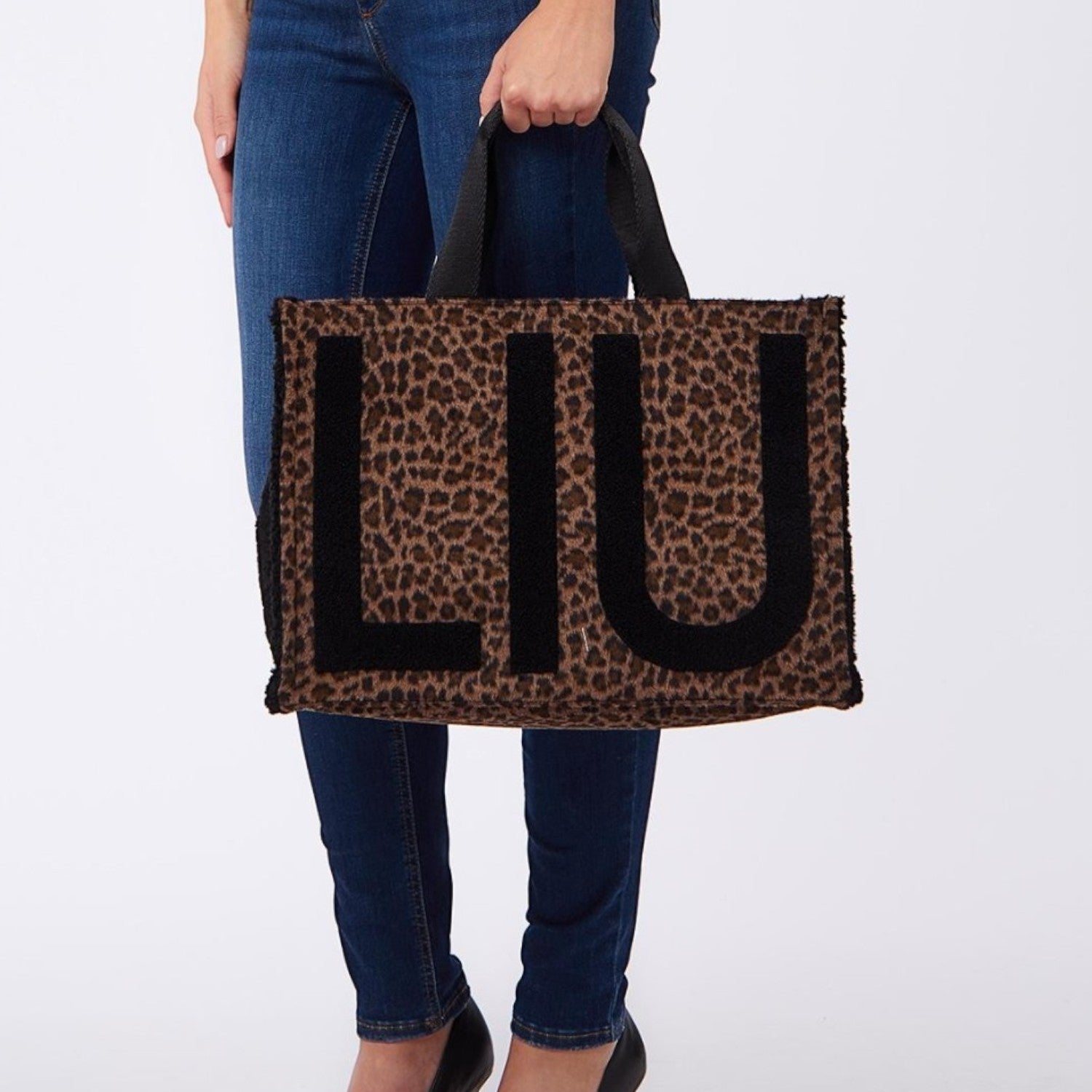 Lieblingstasche Tote Animalier L featuring a brown leopard print pattern with large black LIU lettering and handles.