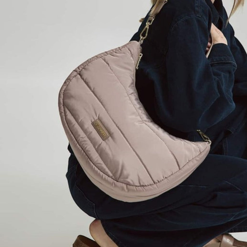 Lieblingstasche Lifetime Buddy M quilted beige hobo bag worn by a woman in dark denim clothing