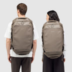 Lieblingstasche Lisbon Duffle Backpack L in taupe worn by a man and woman, showing a versatile travel bag design.