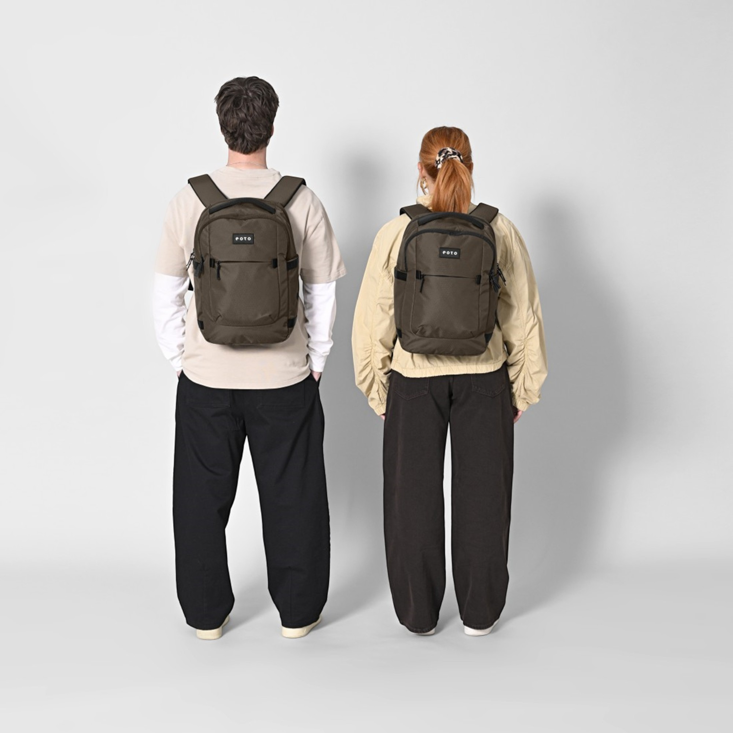 Lieblingstasche eoto Midi20 city backpack in olive green worn by a man and a woman on a light grey background