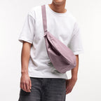 Lieblingstasche Large Moon Bag in dusty rose, worn crossbody by a person in a white t-shirt and grey jeans.