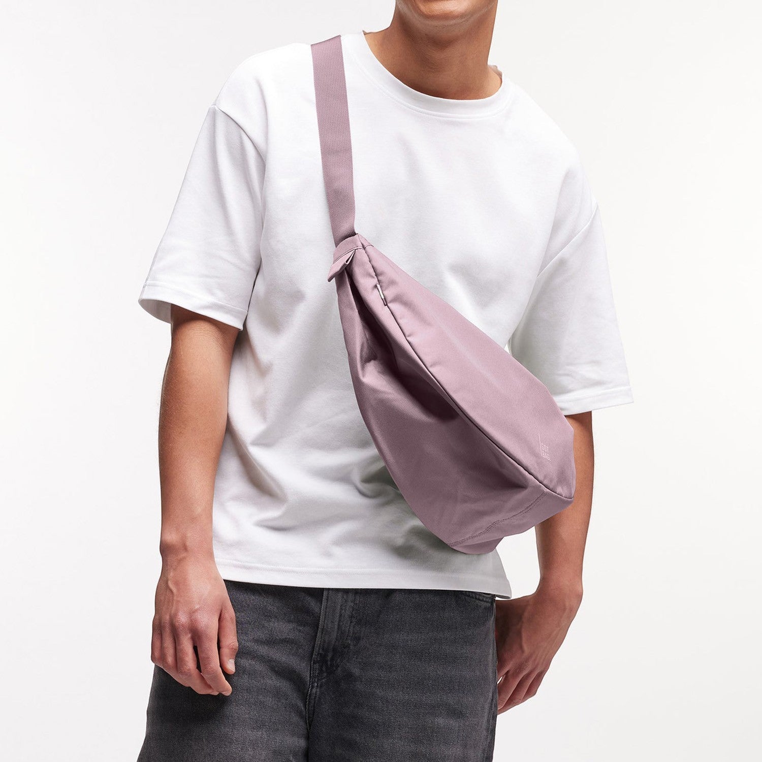 Lieblingstasche Large Moon Bag in dusty rose, worn crossbody by a person in a white t-shirt and grey jeans.