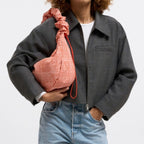 Lieblingstasche Moon Bag Ruffle Large in orange gingham fabric with a drawstring closure and red strap.