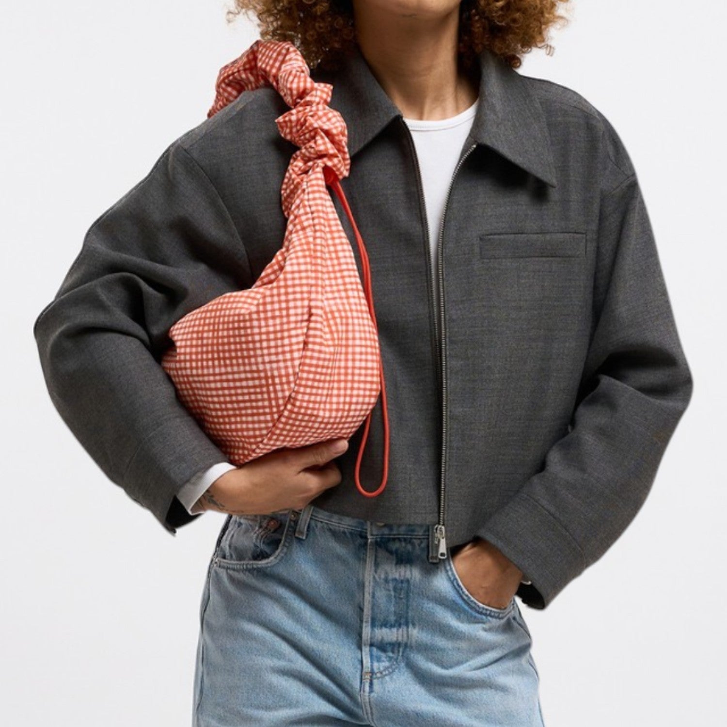 Lieblingstasche Moon Bag Ruffle Large in orange gingham fabric with a drawstring closure and red strap.