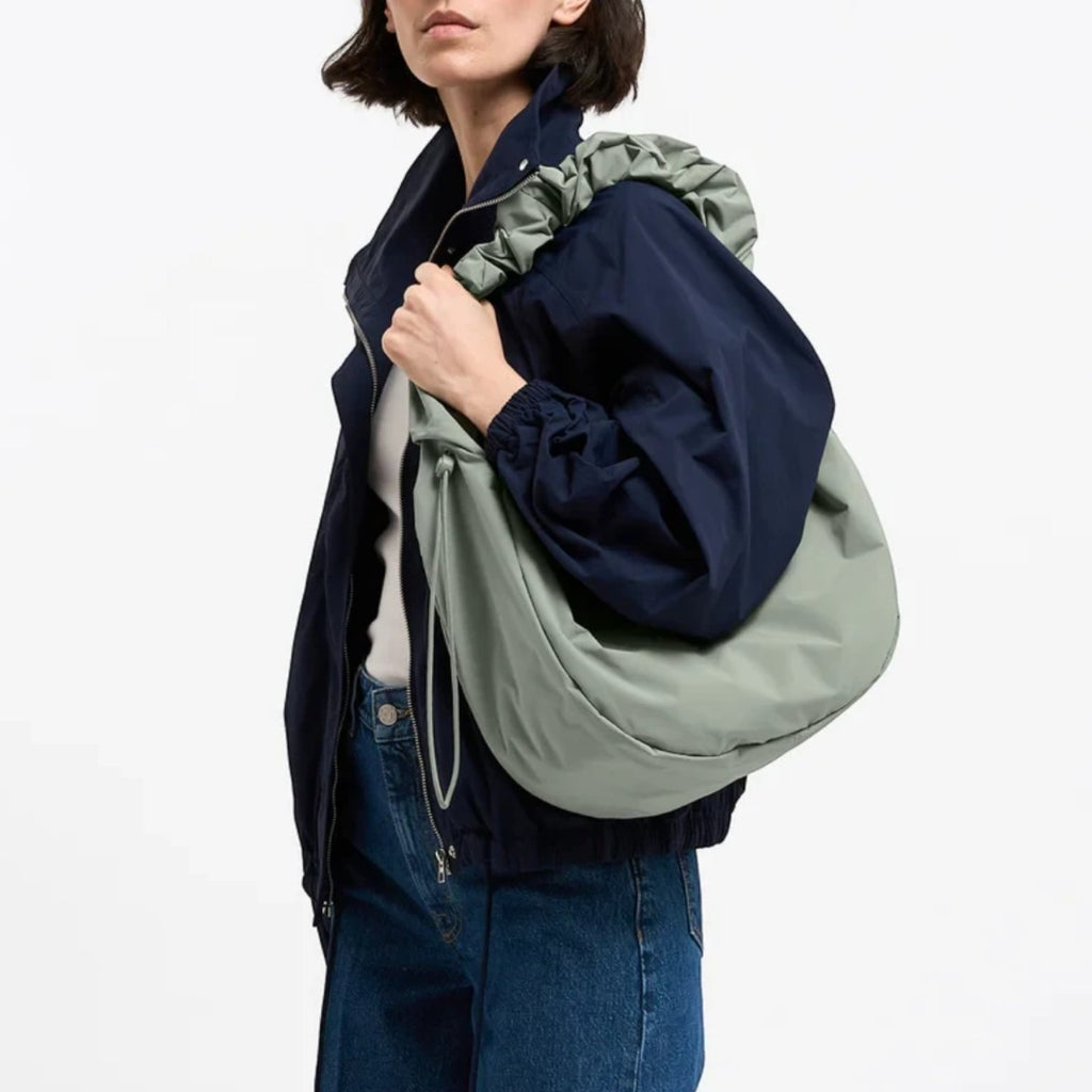 Lieblingstasche Moon Bag Ruffle Large in sage green made from recycled fishing nets worn over the shoulder