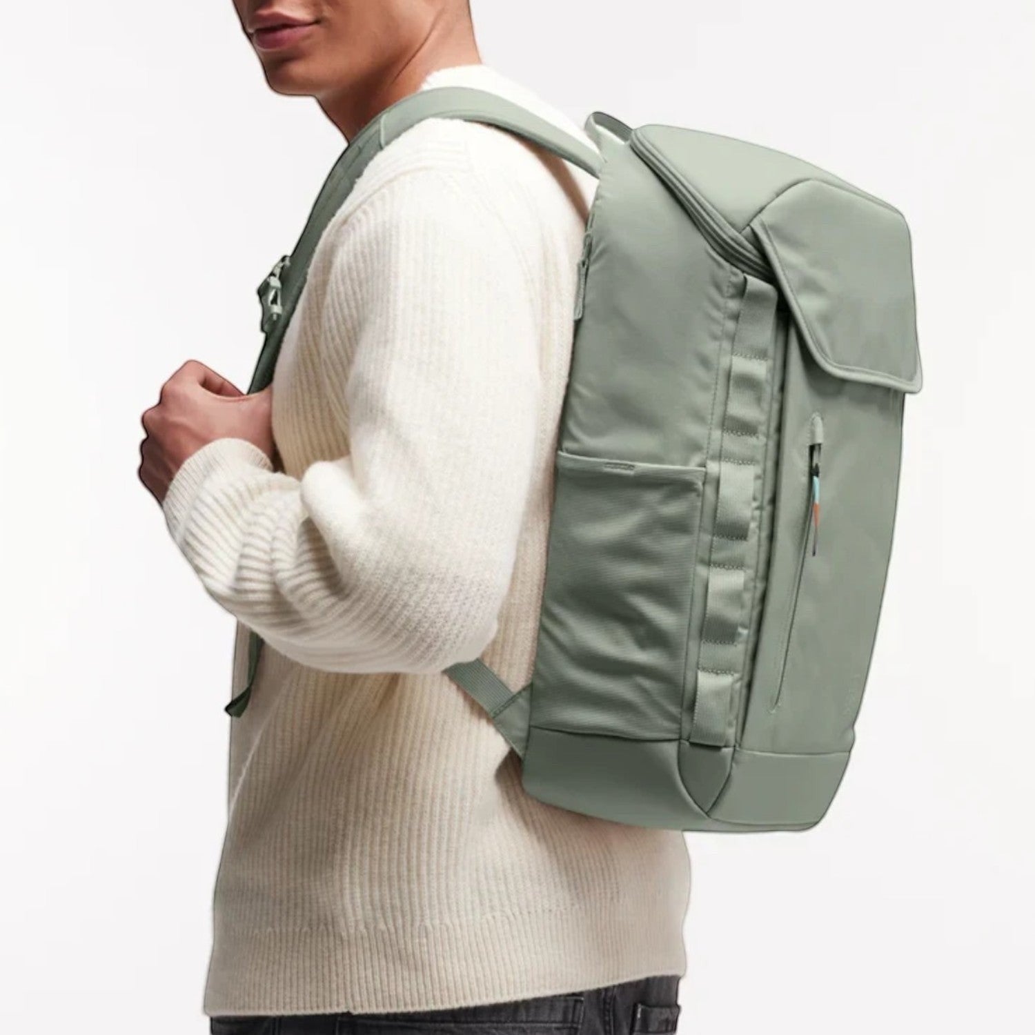 Man wearing a sage green Lieblingstasche Pro Pack laptop backpack with ergonomic straps and side mesh pockets