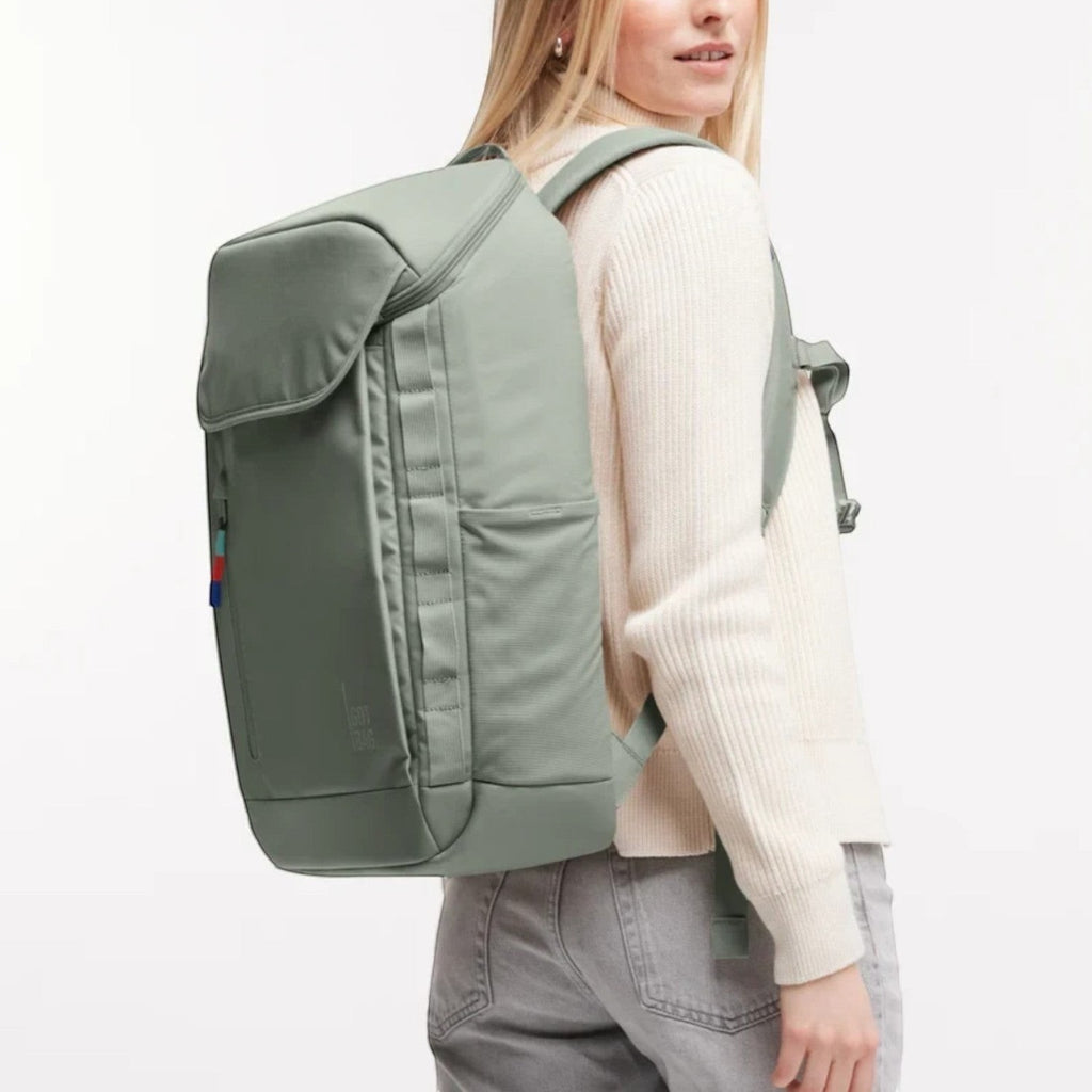 Lieblingstasche Pro Pack sage green laptop backpack worn by a woman, featuring ergonomic straps and side pockets.