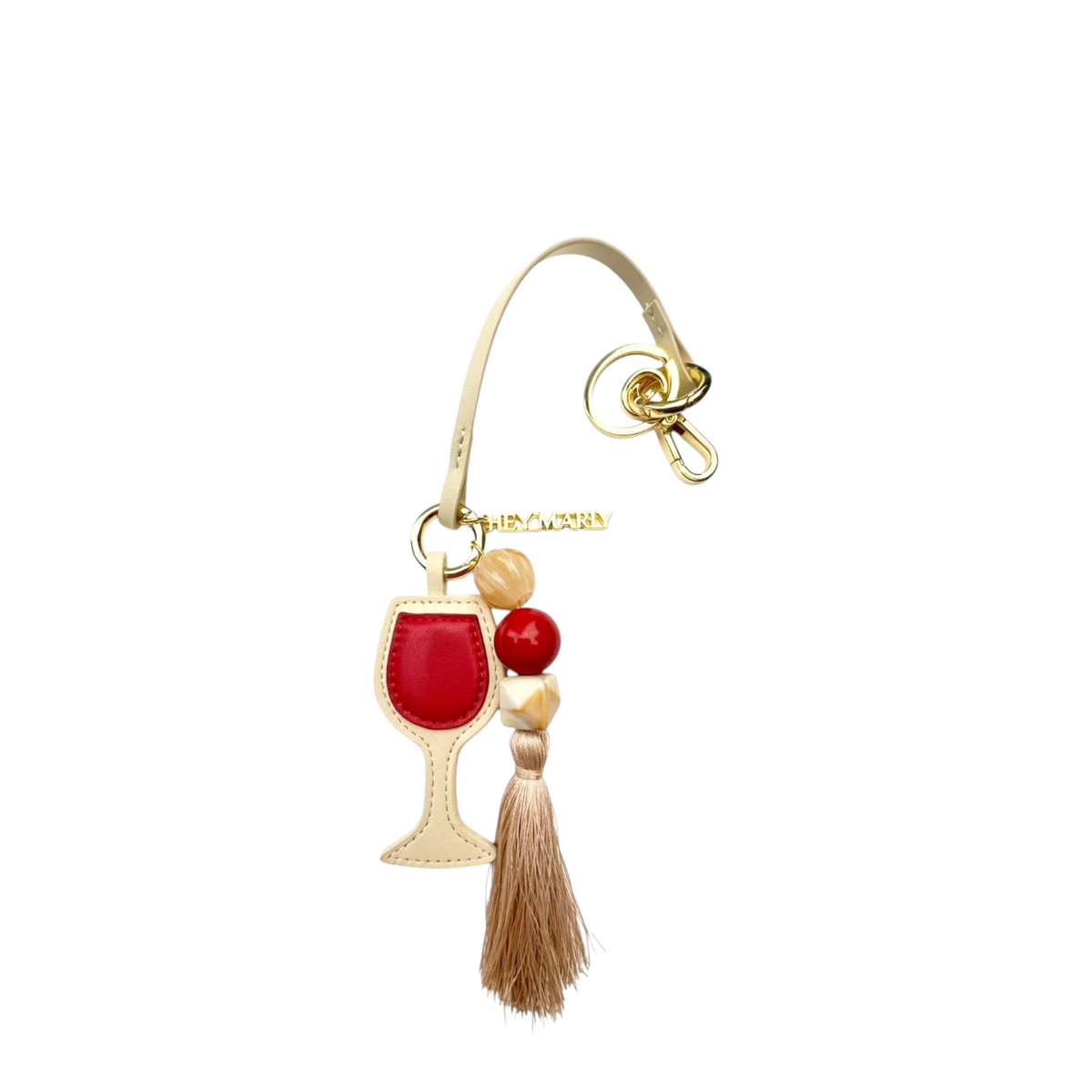 Lieblingstasche red wine glass bag charm with a beige tassel, gold hardware, and decorative beads.
