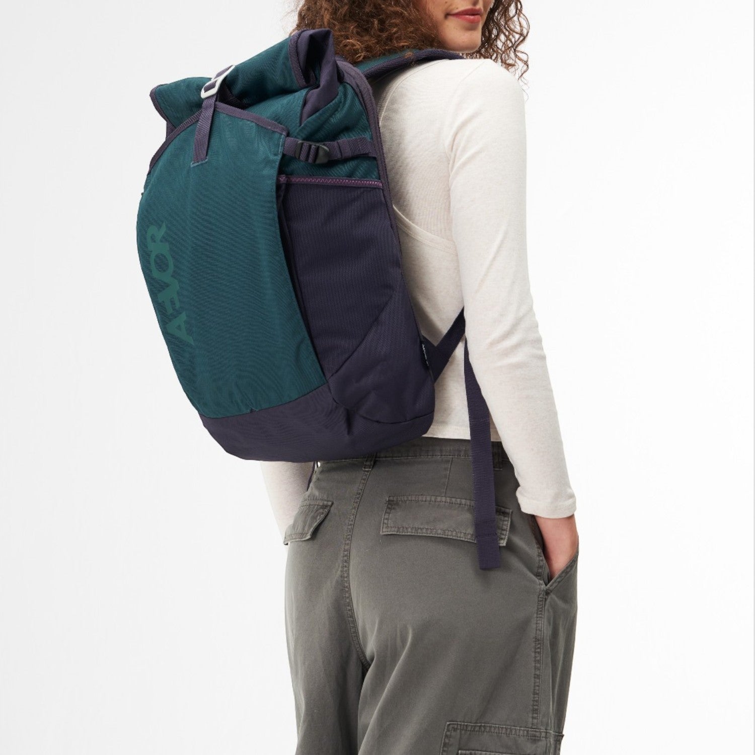 Lieblingstasche Roll Pack 2.0 backpack in dark green and navy blue worn by a woman against a white background