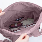 Lieblingstasche Rolltop Easy backpack interior in dusty rose, showing laptop, sunglasses, and phone in pockets.