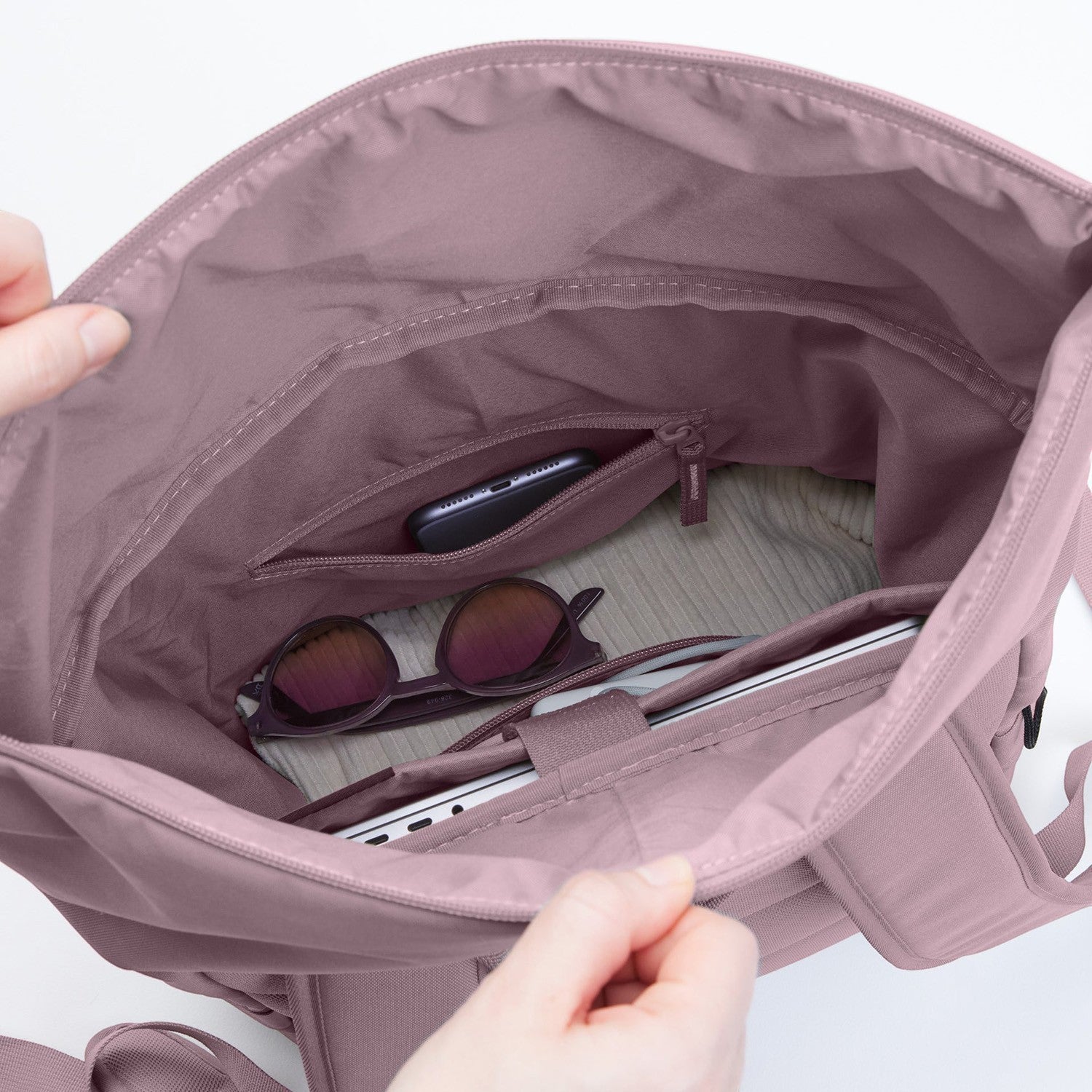 Lieblingstasche Rolltop Easy backpack interior in dusty rose, showing laptop, sunglasses, and phone in pockets.