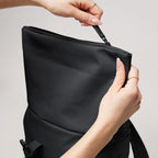 Lieblingstasche Rolltop Easy Small backpack in black with hands opening the zipper closure