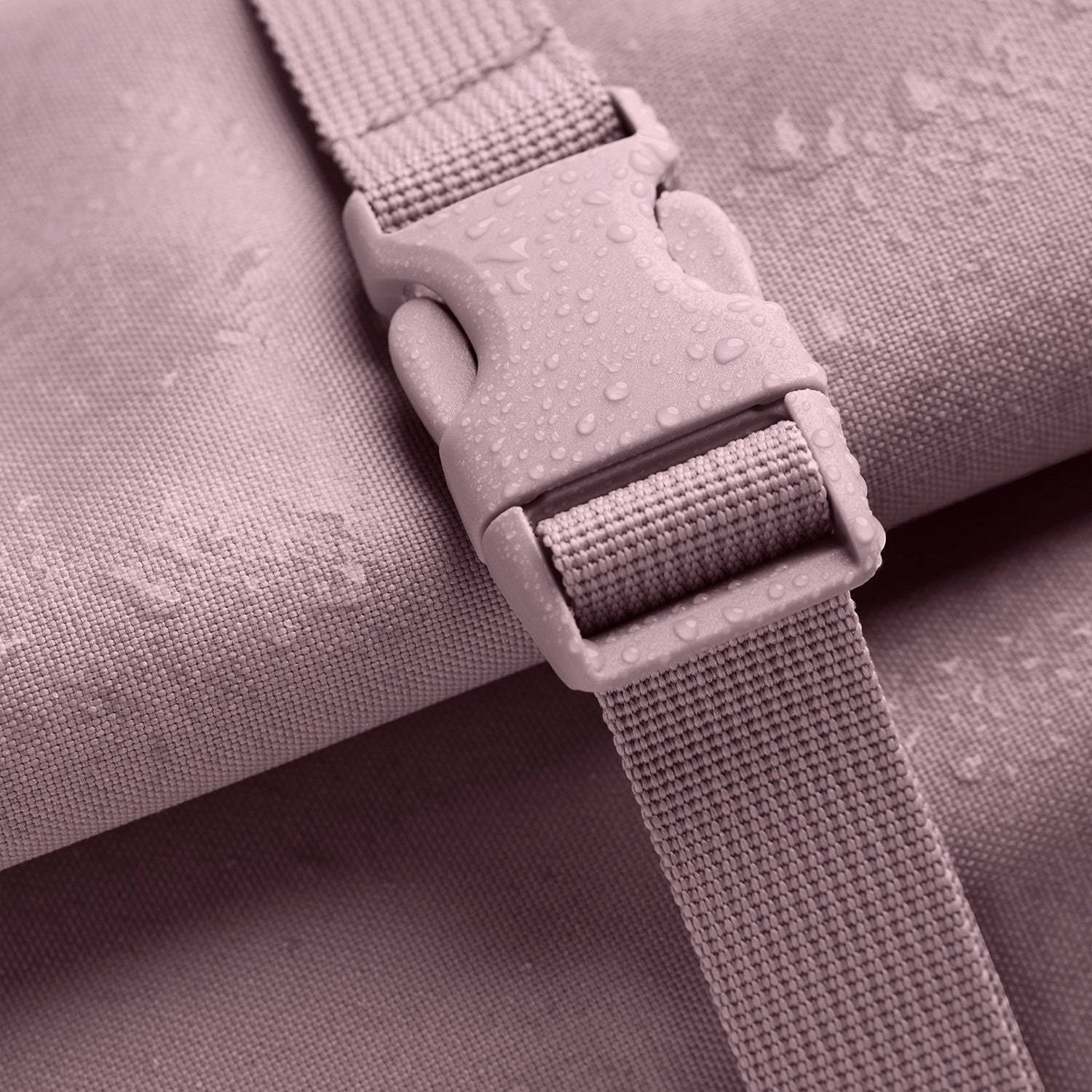 Lieblingstasche Rolltop Lite 2.0 backpack in dusty rose with water droplets on fabric and buckle.