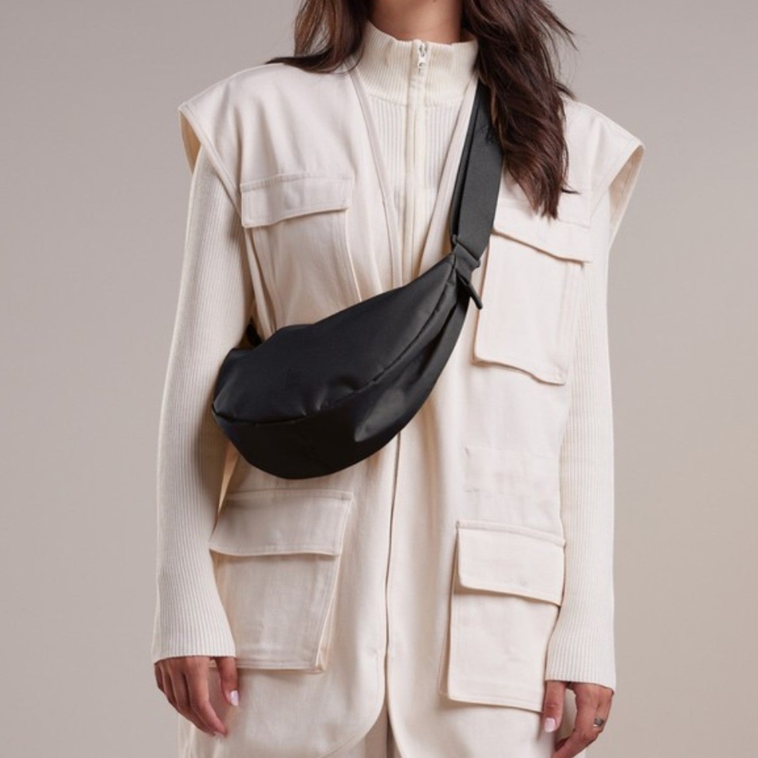 Lieblingstasche small black nylon moon bag worn crossbody by a woman.