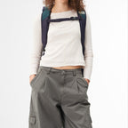 A model wearing a Lieblingstasche Trip Pack backpack with navy and teal straps against a white background