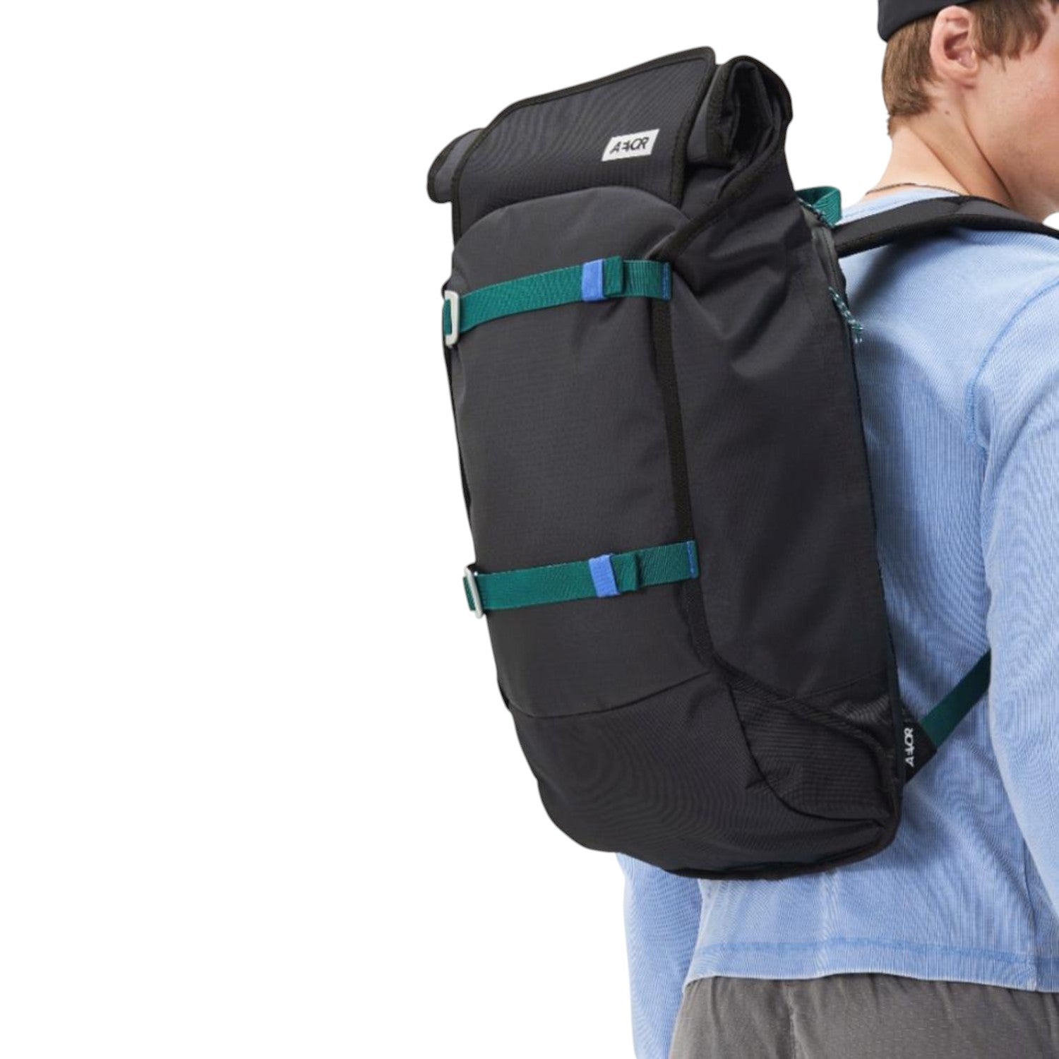 Lieblingstasche Trip Pack black backpack with teal straps worn by a man in a light blue long-sleeve shirt