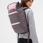Lieblingstasche Trip Pack rolltop backpack in grey and pink with adjustable straps worn by a woman